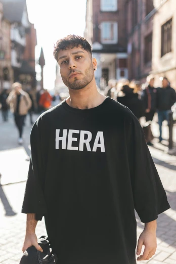 a man in a black shirt is walking down the street, an album cover, by Niko Henrichon, trending on unsplash, hyperrealism, the goddess hera looking angry, trending on r/streetwear, hera, young greek man