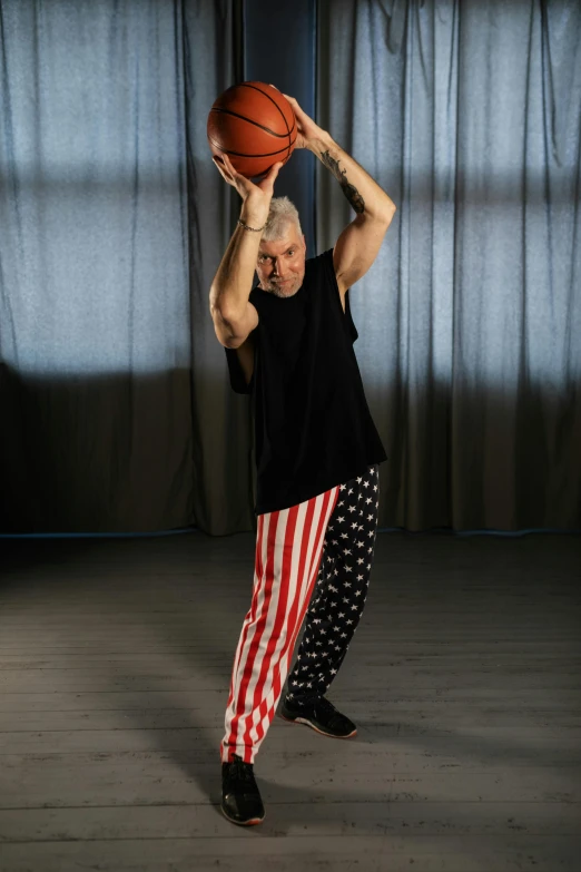 a man holding a basketball over his head, inspired by Graham Forsythe, dribble, stars and stripes, baggy pants, a long-shot from front, 5 5 yo