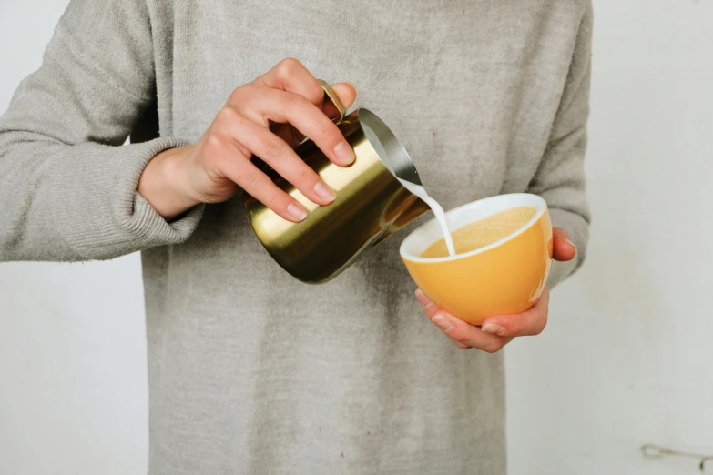 a person pouring a drink into a cup, golden raito, stainless steel, multi-part, neoprene