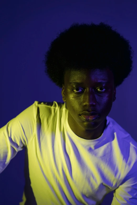 a man in a white shirt holding a tennis racquet, an album cover, inspired by Willian Murai, pexels contest winner, afrofuturism, glowing with colored light, looking to camera, adut akech, with afro