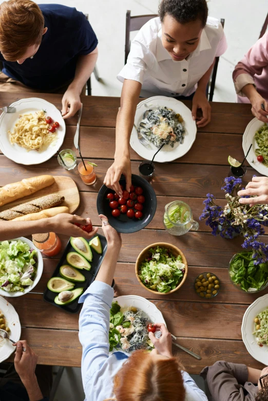 a group of people sitting around a table with plates of food, trending on pexels, cutting a salad, great light, idyllic, avatar image