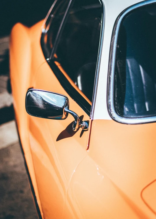 an orange car parked in a parking lot, pexels contest winner, photorealism, 1 9 7 0 s car window closeup, profile image, 🚿🗝📝