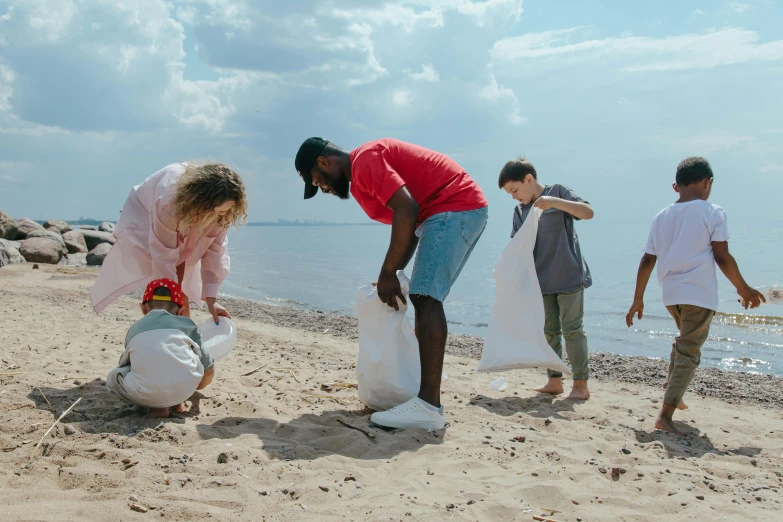 a group of people standing on top of a sandy beach, rubbish, filling with water, virgil abloh, families playing