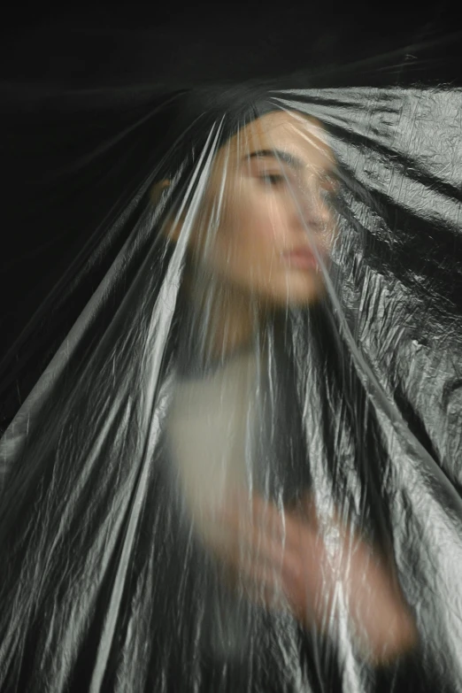 a woman holding a black umbrella over her head, an album cover, inspired by Dora Maar, plastic wrap, ignant, pat steir, cindy avelino