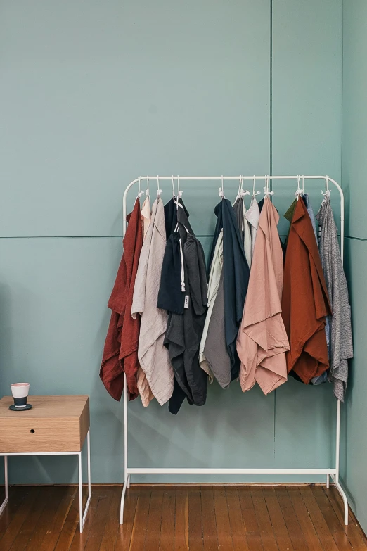 clothes hanging on a rack in a room, by Nina Hamnett, solid colours material, zoomed in, dwell, tech robes