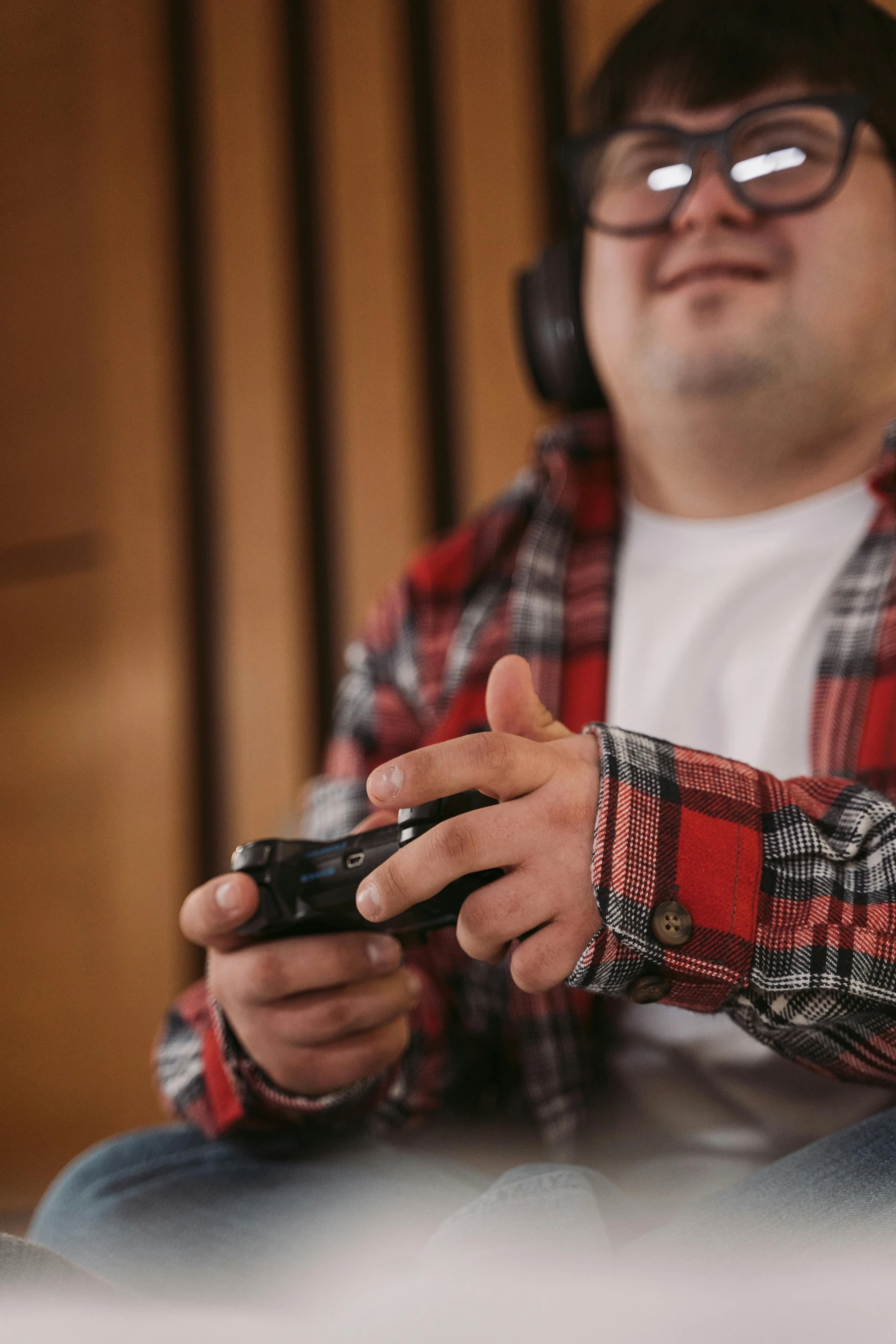 a man wearing headphones playing a video game, pexels, realism, wearing a red lumberjack shirt, obese ), ap news, hand controlling