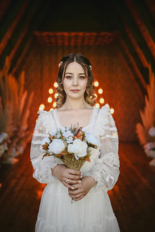 a woman in a wedding dress holding a bouquet, a portrait, inspired by Elsa Bleda, pexels contest winner, warm orange lighting, 4k symmetrical portrait, cottagecore hippie, with archways