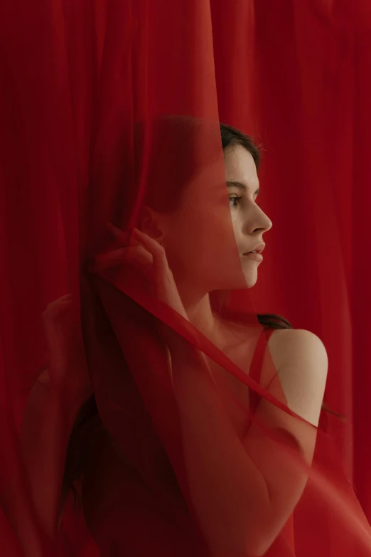 a woman standing in front of a red curtain, pale skin, red fabric, see - through, shot with sony alpha