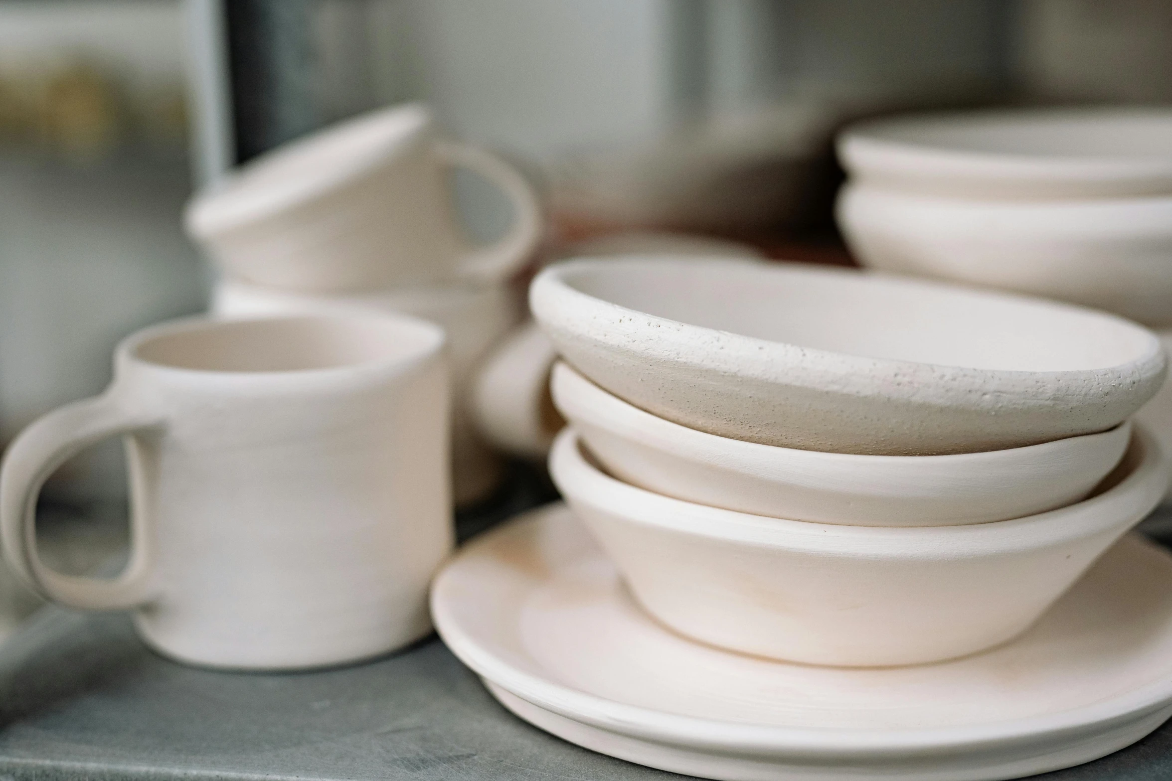 a stack of white dishes sitting on top of a counter, inspired by Lewis Henry Meakin, unsplash, process art, made out of clay, small manufacture, warm shading, children's