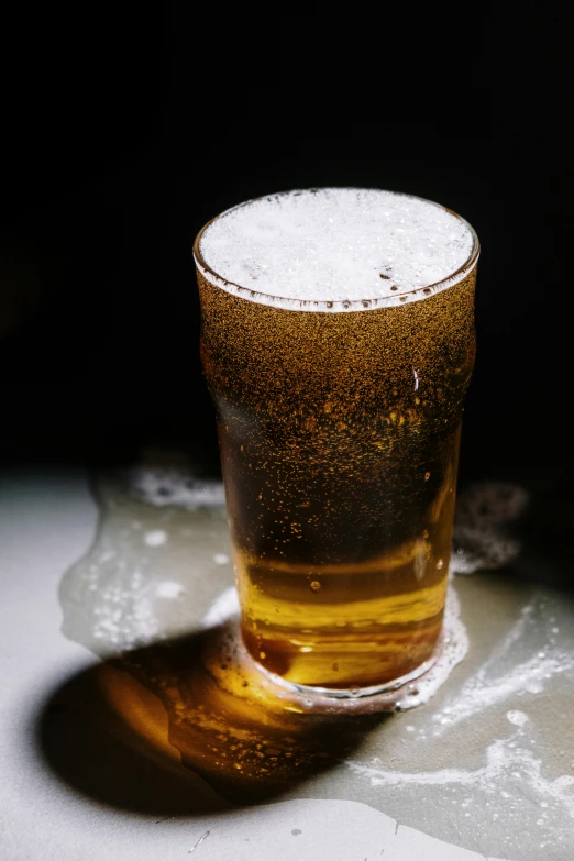 a glass of beer sitting on top of a table, light scatter, round-cropped, fluids, very sweaty