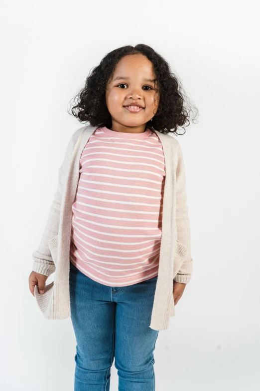 a little girl standing in front of a white background, inspired by Sophia Beale, shutterstock contest winner, pink shirt, wearing a cardigan, rounded lines, official product image