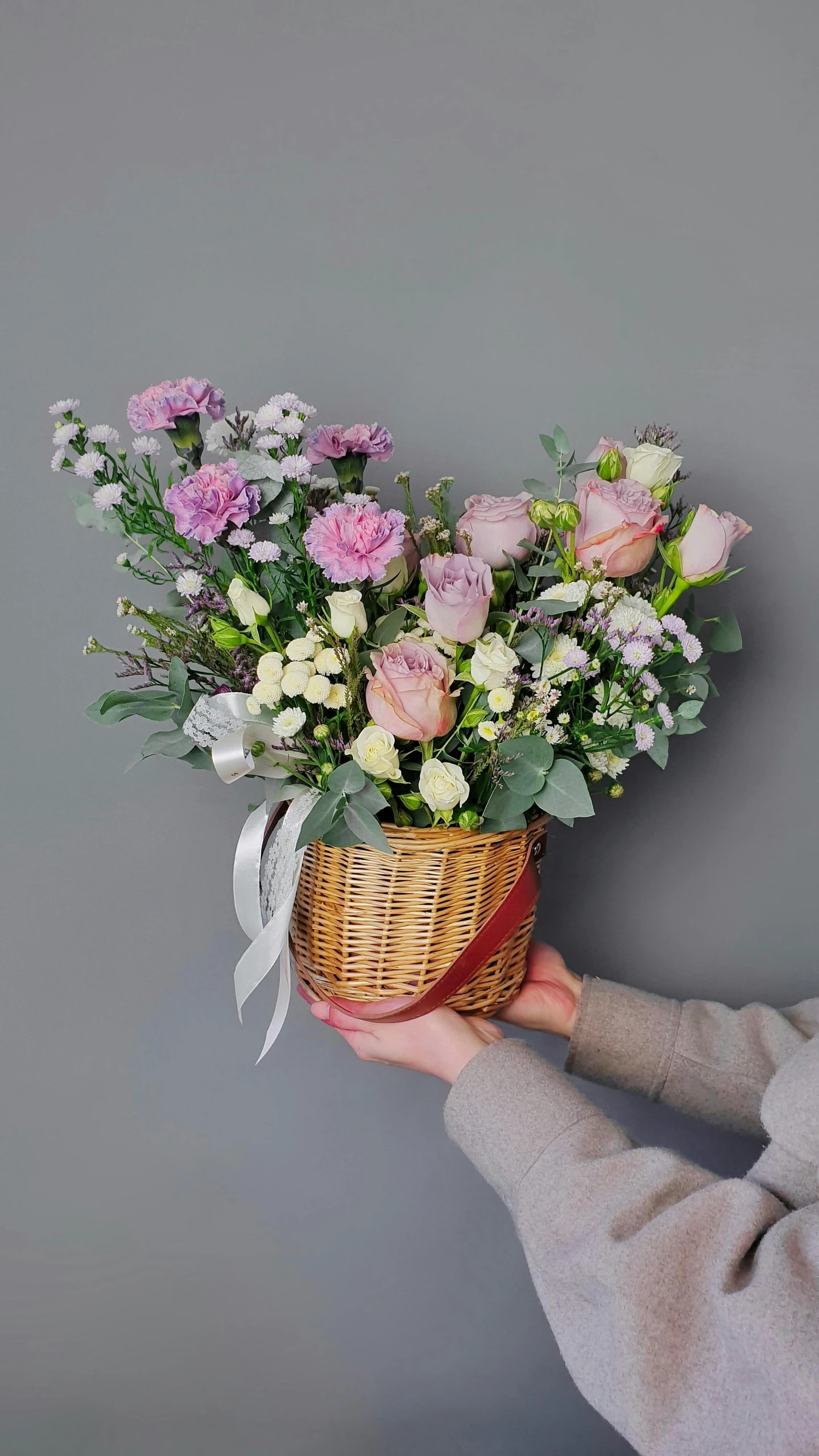 a person holding a basket with flowers in it, inspired by Annie Rose Laing, light purple mist, on grey background, natural point rose', sweet hugs