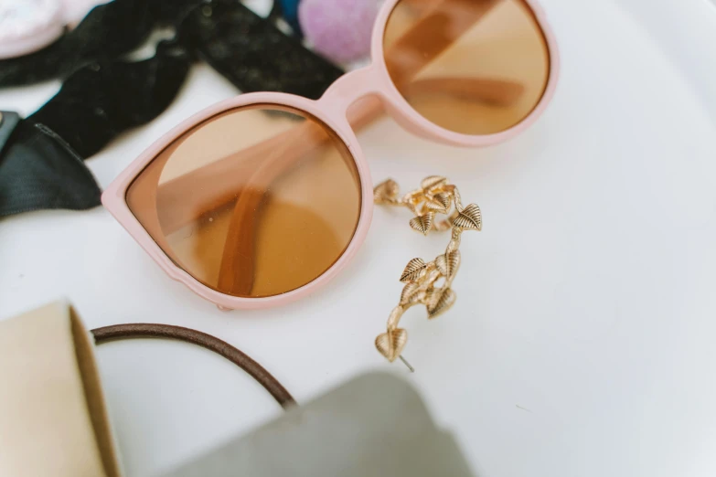 a pair of sunglasses sitting on top of a table, earring