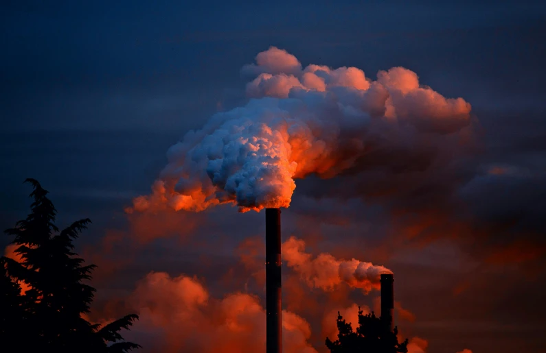 a factory with a lot of smoke coming out of it, by Jesper Knudsen, pexels contest winner, sumatraism, crepuscule, thumbnail, chimney, brilliantly coloured