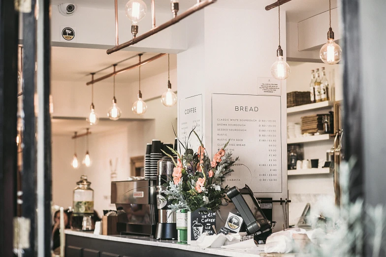 a coffee shop with a bunch of flowers on the counter, inspired by Richmond Barthé, trending on unsplash, private press, lights inside, white marble interior photograph, award-winning crisp details”, open plan