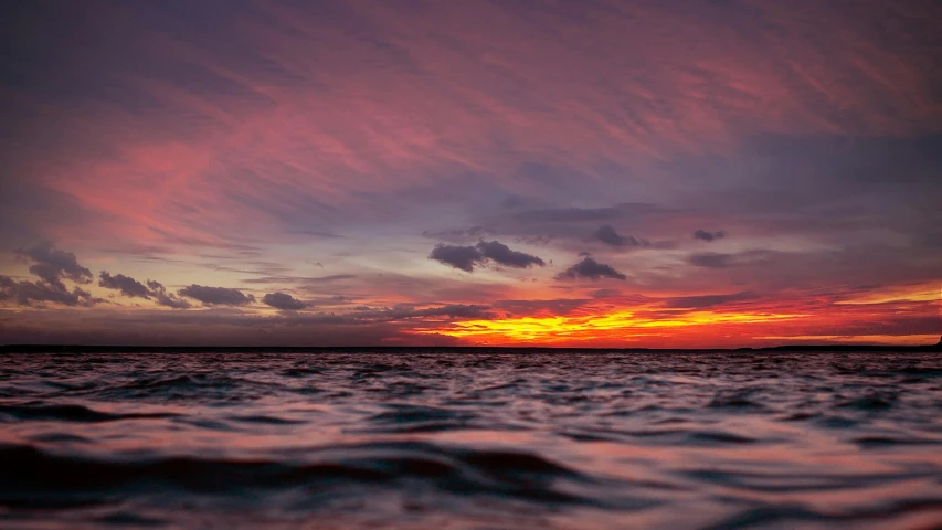 a large body of water with a sunset in the background, by Daniel Lieske, unsplash contest winner, big island, orange / pink sky, panoramic shot, detailed photo 8 k