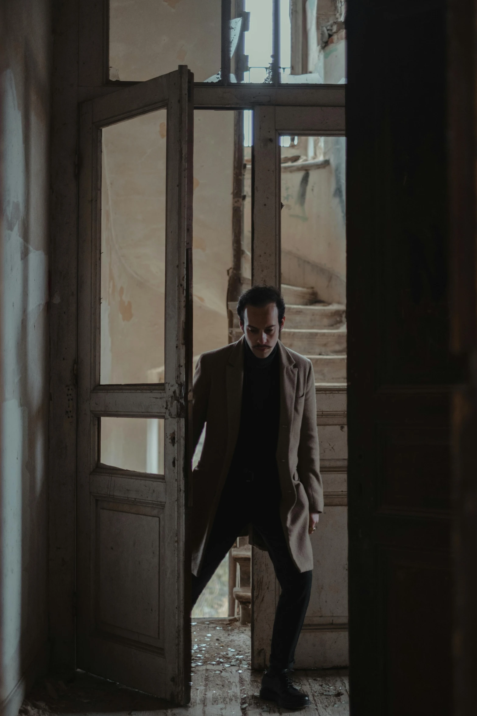 a man that is standing in a doorway, an album cover, by Pablo Rey, pexels contest winner, giorgio a. tsoukalos, dramatic movie still, beige and dark atmosphere, shooting