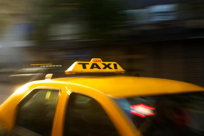 a yellow taxi cab driving down a city street, pexels contest winner, happening, square, soft focus blur, avatar image