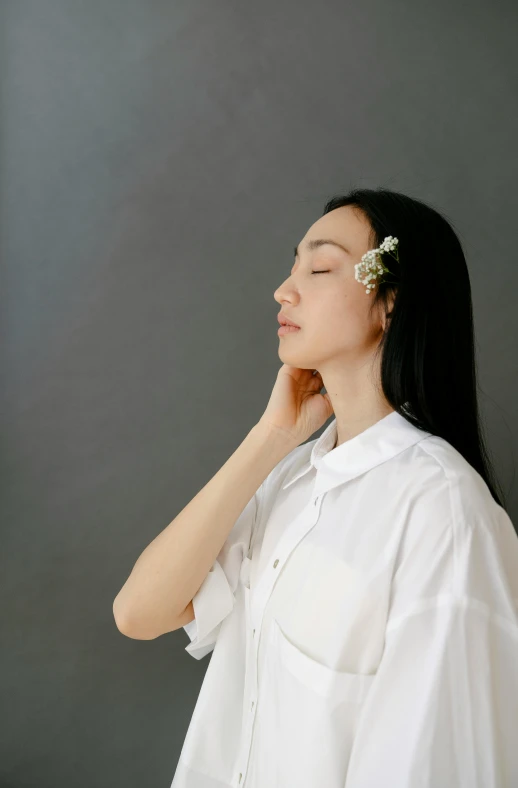 a woman wearing a white shirt with a flower in her hair, by Shang Xi, trending on unsplash, aestheticism, kiko mizuhara, large)}], relaxed posture, image apothecary