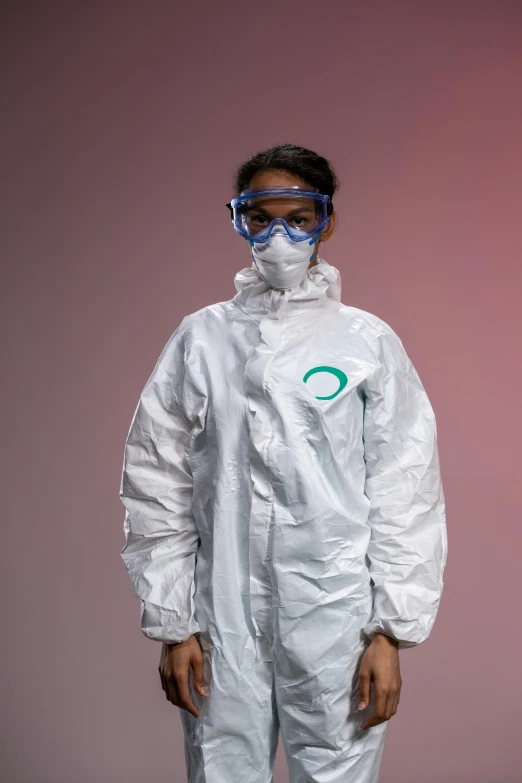 a man wearing a protective suit and goggles, by Ellen Gallagher, photograph of a techwear woman, enso, sterile background, a person standing in front of a