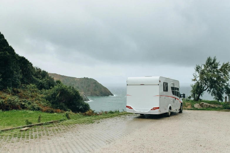 a trailer parked on the side of a road next to a body of water, by Matthias Stom, unsplash contest winner, les nabis, cornwall, rosalia vila i tobella, tournament, on the coast