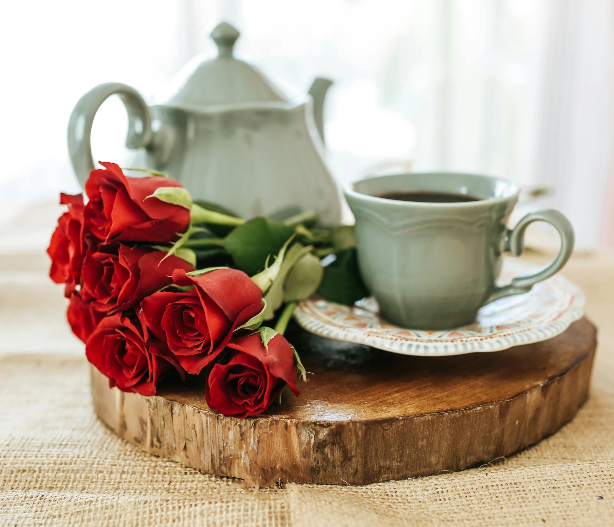 a tea pot sitting on top of a table next to a cup of coffee, by Julia Pishtar, romanticism, red roses at the top, on a wooden tray, red and teal color scheme, carson ellis