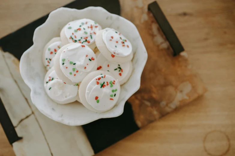 a white bowl filled with white frosting and sprinkles, a colorized photo, trending on pexels, santa, therookies, mozzarella, trending on vsco