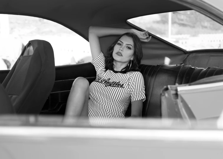 a woman sitting in the back seat of a car, a black and white photo, by Kristian Zahrtmann, unsplash, conceptual art, portrait of sherlyn chopra, shirt, striped, adriana chechik