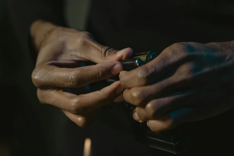a close up of a person holding a cell phone, gunsmithing, graded with davinci resolve, black man, unclipped fingernails