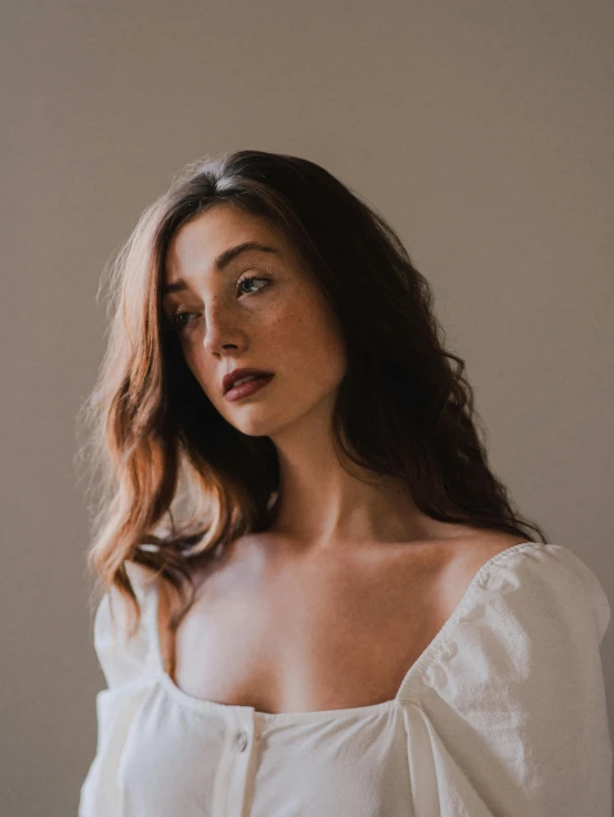 a woman standing in front of a window, an album cover, inspired by Elsa Bleda, renaissance, wearing a white button up shirt, headshot profile picture, bare shoulders, kailee mandel