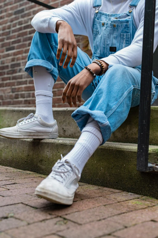 a man sitting on the steps of a building, by Jan Tengnagel, trending on pexels, realism, wearing white sneakers, non-binary, white and pale blue, promotional image