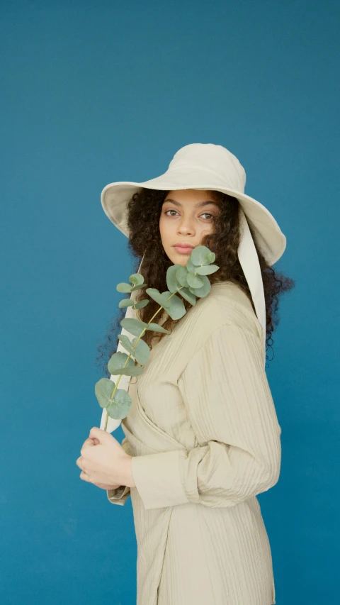 a woman in a white hat and trench coat, inspired by Esaias Boursse, unsplash, eucalyptus, press shot, wearing wide sunhat, sza