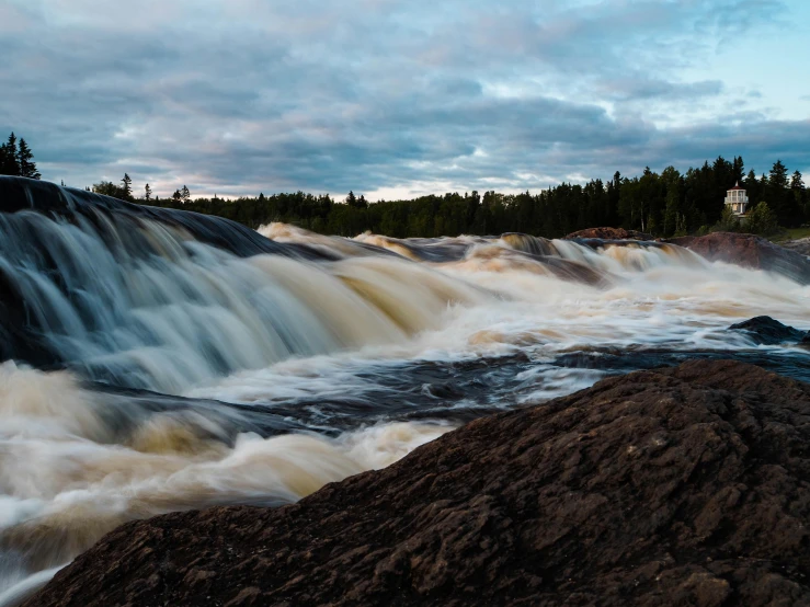 a large waterfall in the middle of a forest, by Jesper Knudsen, pexels contest winner, hurufiyya, great river, minn, grey, dessert