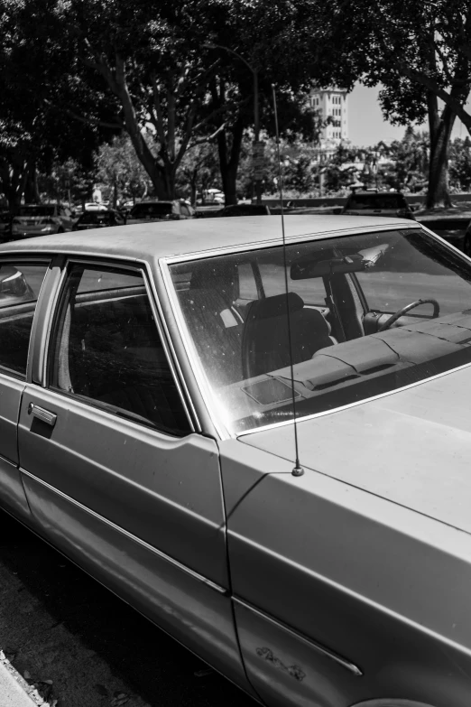 a black and white photo of a car parked on the side of the road, square lines, profile image, eighties amateur photography, low iso