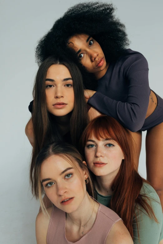 a group of women standing next to each other, inspired by Nan Goldin, trending on pexels, renaissance, wild ginger hair, gorgeous young model, high angle, mixed race