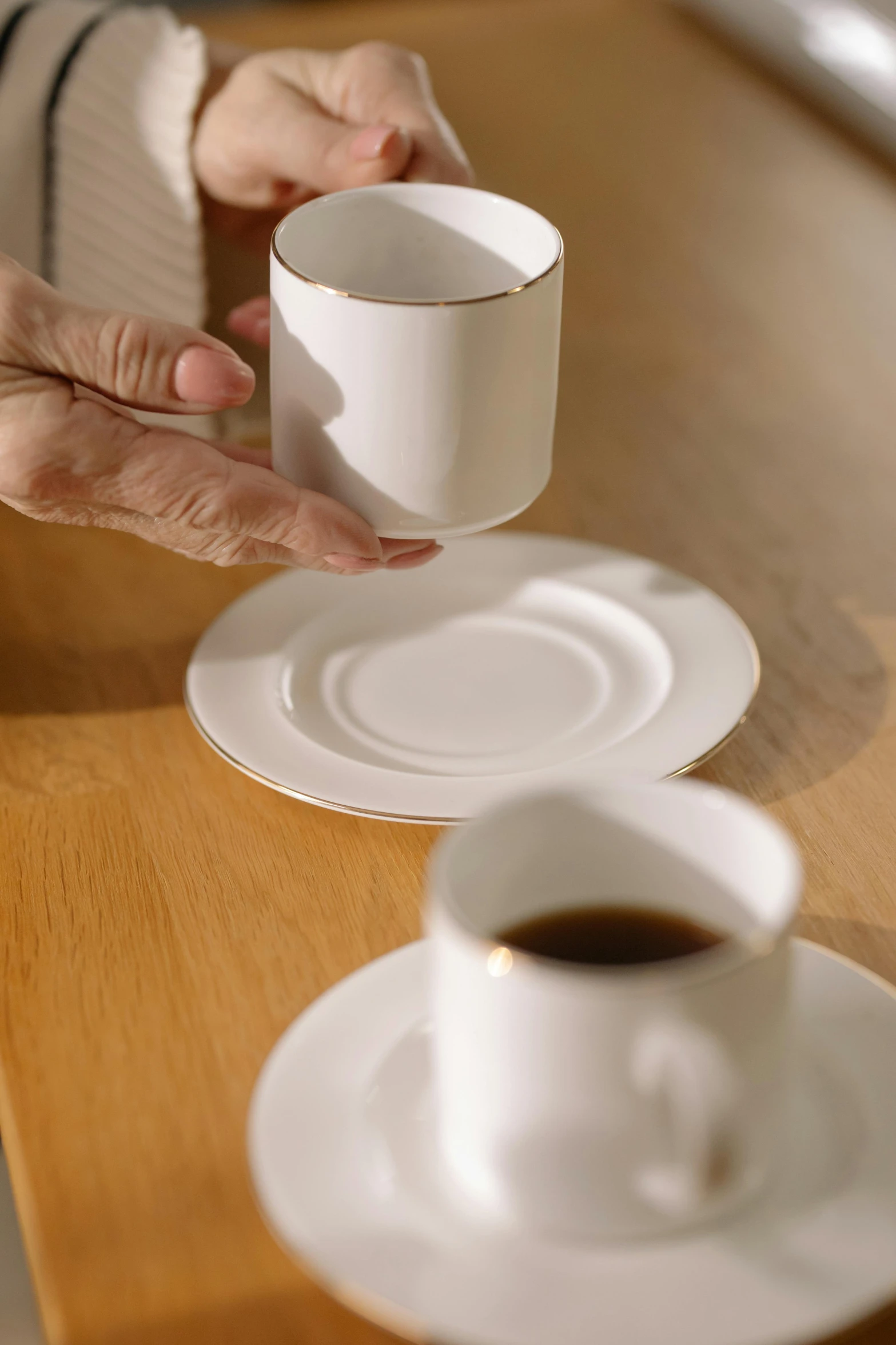 a close up of a person holding a cup of coffee, pan and plates, porcelain forcefield, curated collections, white