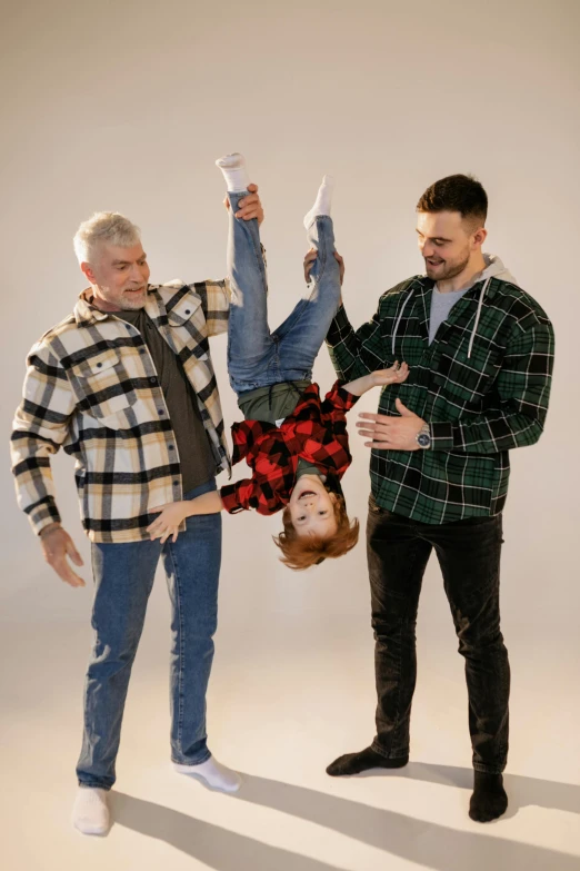 a couple of men standing next to each other, with a kid, posing like a falling model, plaid shirt, promo image