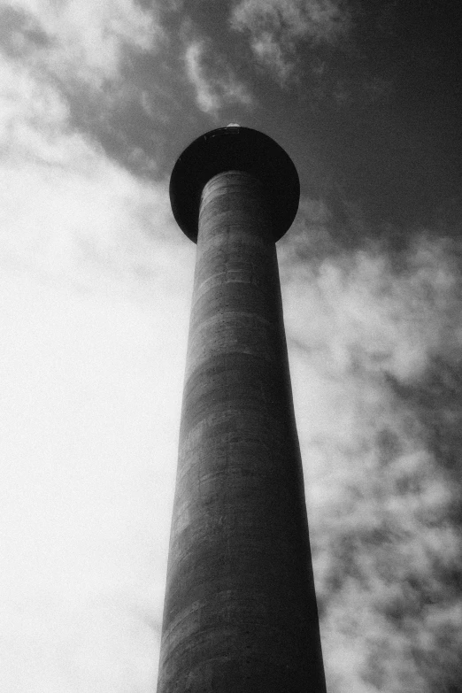 a black and white photo of a tall tower, inspired by André Kertész, unsplash, chimney, circular, industrial colours, holga hasselblad