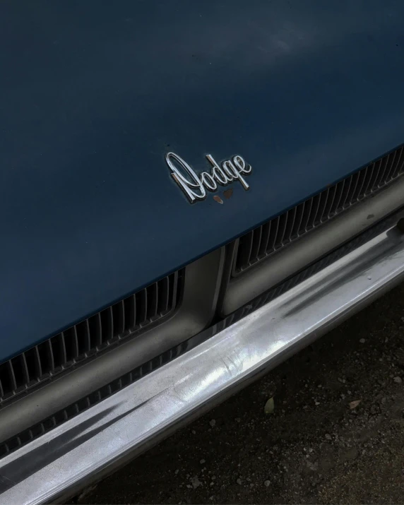 a close up of the front end of a blue car, an album cover, by Doug Wildey, pexels contest winner, soft color dodge, slight overcast, taken in the late 1970s, signature on the bottom