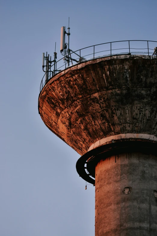 a tall tower with a clock on top of it, inspired by Elsa Bleda, unsplash, brutalism, watertank, low quality photo, rounded roof, sewer