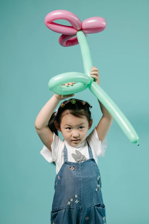 a little girl holding a bunch of balloons, inspired by Li Fangying, pexels contest winner, conceptual art, very long neck, overalls, promotional still, studio portrait