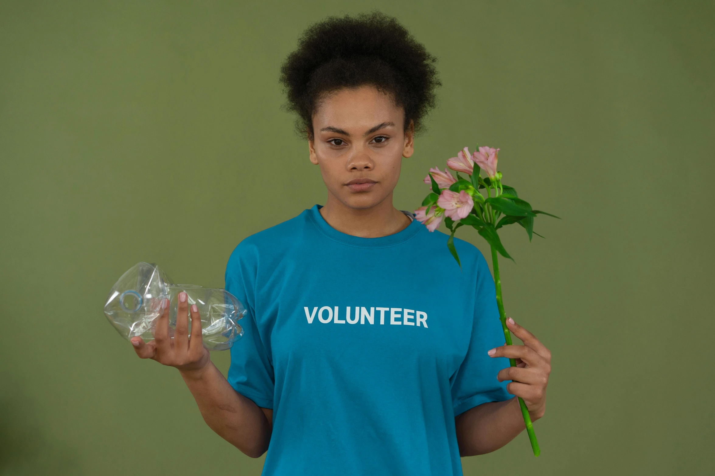 a woman holding a flower in one hand and a plastic bottle in the other, pexels contest winner, tshirt, cyan, y2k”, diverse