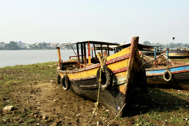 a couple of boats that are sitting in the dirt, bengal school of art, on a riverbank, portrait mode photo, image