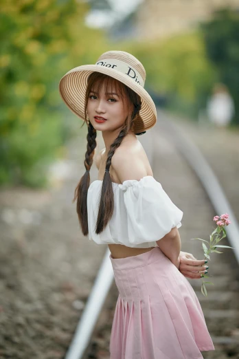a woman standing on a train track holding a flower, a portrait, inspired by Dai Xi, pexels contest winner, pigtails hairstyle, white straw flat brimmed hat, cai xukun, 5 0 0 px models