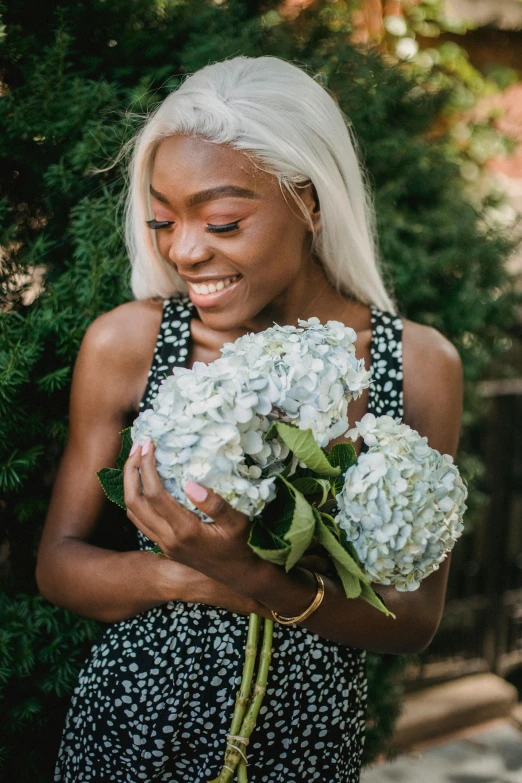 a woman in a black and white dress holding a bunch of flowers, millennial vibes, ( ( dark skin ) ), hydrangea, a radiant