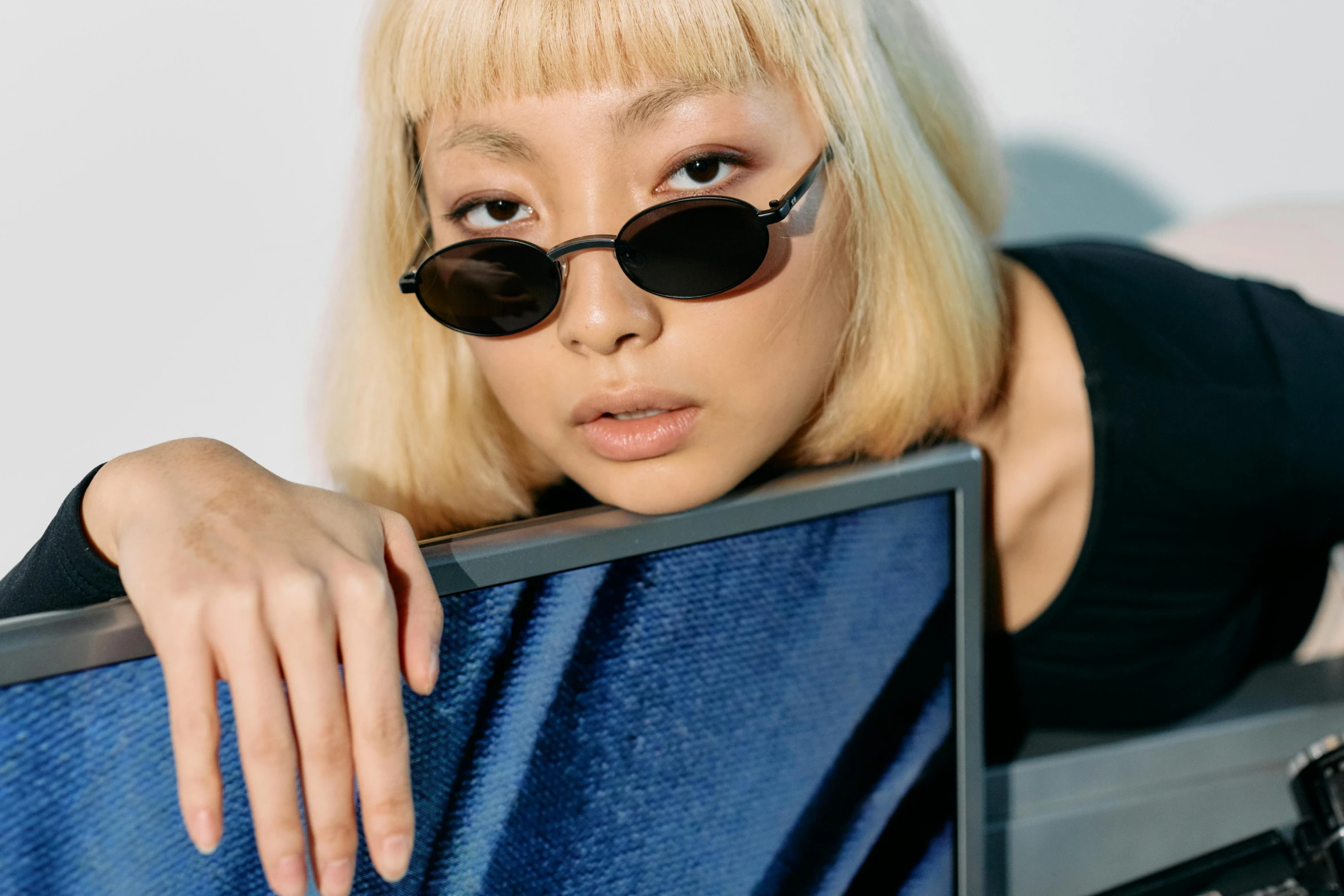 a woman sitting in front of a laptop computer, an album cover, trending on pexels, realism, technological sunglasses, ethnicity : japanese, non binary model, 2 0 0 0's photo