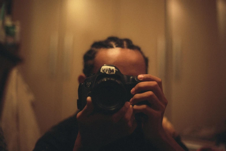 a man taking a picture of himself in a mirror, a picture, inspired by Elsa Bleda, pexels contest winner, camera close up, low light, looking back at the camera, ariel perez