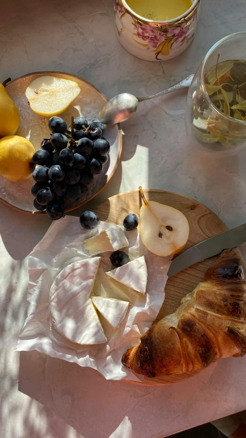 a table that has a bunch of food on it, a still life, pexels, photorealism, pear, ivory and black marble, warm sunshine, cheese