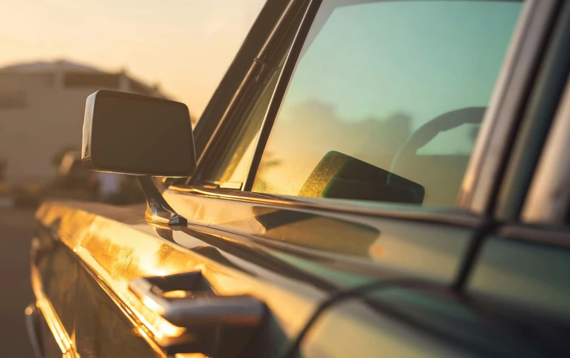 a car is parked on the side of the road, a picture, unsplash, renaissance, golden hour closeup photo, william eggleston style, profile image, mirror and glass surfaces