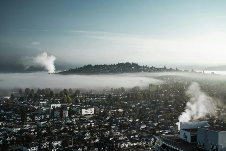 a view of a city on a foggy day, a matte painting, by Tobias Stimmer, unsplash contest winner, photo of zurich, smoke and gas, british columbia, slide show